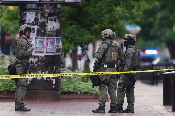 Law enforcement officials investigate after an attack on the Pearl Street Mall, Sunday, June 1, 2025, in Boulder, Colo. (AP Photo/David Zalubowski)