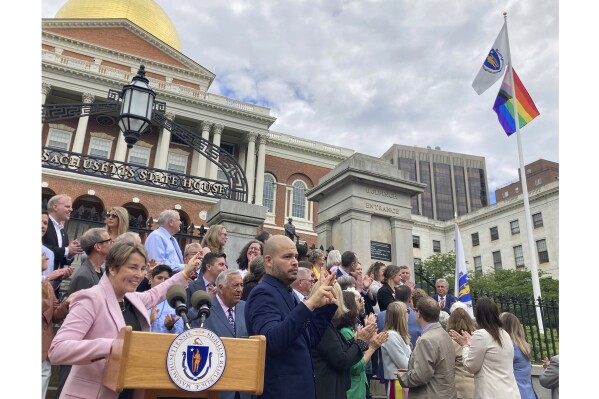 Massachusetts Gov. Maura Healey, left, joins with lawmakers and members of the LGBTQ community Wednesday, June 5, 2024, to mark Pride Month in front of the State House in Boston. Healey, one of America's first two openly lesbian elected governors, took the opportunity to oversee the raising of the Pride flag on the Statehouse lawn. The ceremony marked the 20th anniversary of the legalization of same-sex marriage in Massachusetts, the first state to allow the unions. (AP Photo/Steve LeBlanc)