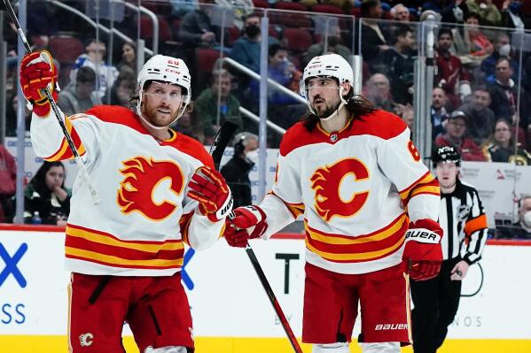 Calgary Flames defenseman Christopher Tanev, right, goes to celebrate his goal against the Arizona Coyotes with center Blake Coleman (20) during the second period of an NHL hockey game Wednesday, Feb. 2, 2022, in Glendale, Ariz. (AP Photo/Ross D. Franklin)