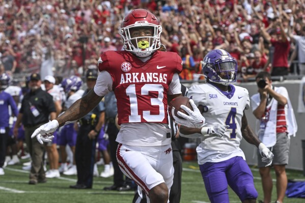 Arkansas wide receiver Jaedon Wilson (13) celebrates as he crosses the goal line to score a touchdown in front of Western Carolina defensive back CJ Williams (4) during the first half of an NCAA college football game Saturday, Sept. 2, 2023, in Little Rock, Ark. (AP Photo/Michael Woods)