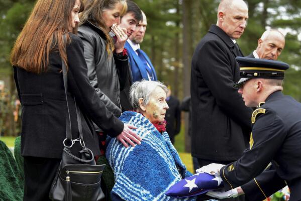 Patricia Lyons, 90, the only remaining sibling of U.S. Army Sgt. Alfred Sidney, is handed the American flag from his burial service in Littleton, N.H., on Thursday, Dec. 8, 2022. The remains of Sidney, who went missing during the Korean War in 1951 and was later reported to have died in a prisoner of war camp, were recently identified and brought back home. (Robert Blechl/Caledonian-Record via AP)