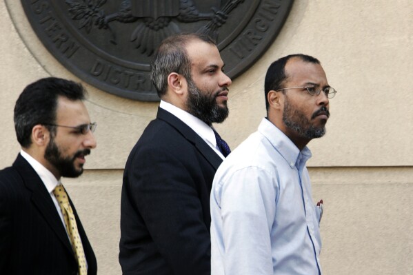 FILE - In this April 18, 2005 file photo, Ali Al-Tamimi, center, walks with two unidentified men, as he leaves the Albert V. Bryan Courthouse, in Alexandria, Va. A judge on Thursday, July 18, 2024, overturned a conviction carrying a life sentence for Al-Tamimi, who was found guilty of soliciting treason after the Sept. 11 attacks. (ĢӰԺ Photo/Manuel Balce Ceneta, File)