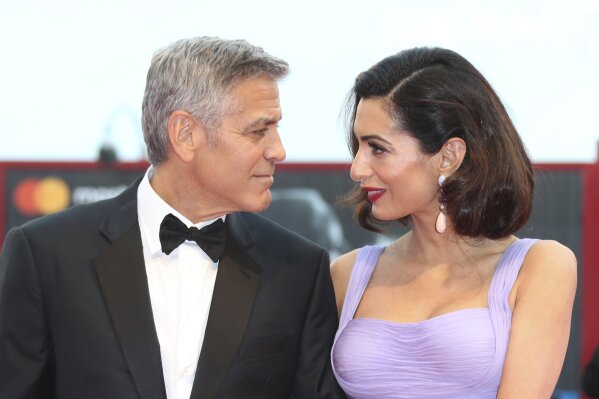 
              Director George Clooney and his wife Amal Clooney pose for photographers upon arrival at the premiere of the film 'Suburbicon' during the 74th edition of the Venice Film Festival in Venice, Italy, Saturday, Sep. 2, 2017. (Photo by Joel Ryan/Invision/AP)
            