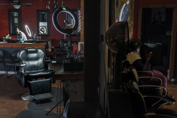 The barber chair where Sherman Peebles used to cut hair on Saturdays sits empty at Overflo Beauty and Barber Shop in Columbus, Ga., Wednesday, March 9, 2022. In late September, as Peebles, who also worked as a sheriff's deputy, lay in a hospital bed, COVID-19's toll reached 675,000, surpassing the number of Americans killed by the Spanish flu pandemic a century ago. He died at age 49 the next day. Months later, his best friend and shop owner, Gerald Riley, still arrives at the shop each Saturday expecting to see Peebles' truck parked outside. At day's end, he thinks back to the routine he and his friend of 25 years always followed when closing. "I love you, brother," they'd tell one another. How could Riley have known those would be the last words they'd ever share? (AP Photo/David Goldman)