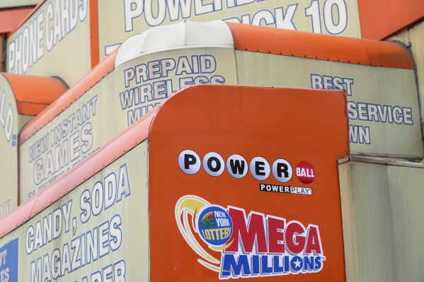 FILE - The awnings of a store advertise the sale of lottery tickets, including Mega Millions, Wednesday, Jan. 11, 2023, in New York. The Mega Millions prize has grown to an estimated $1.05 billion for the Tuesday, Aug. 1, 2023, drawing. (AP Photo/Seth Wenig, File)