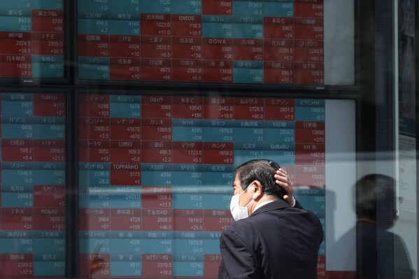 A person looks at an electronic stock board showing Japan's stock princes at a securities firm Tuesday, April 2, 2024, in Tokyo. Asian shares were mixed on Tuesday after Wall Street pulled back from its record following a shaky day of trading, putting at least a temporary halt to its huge rally since Halloween. (AP Photo/Eugene Hoshiko)