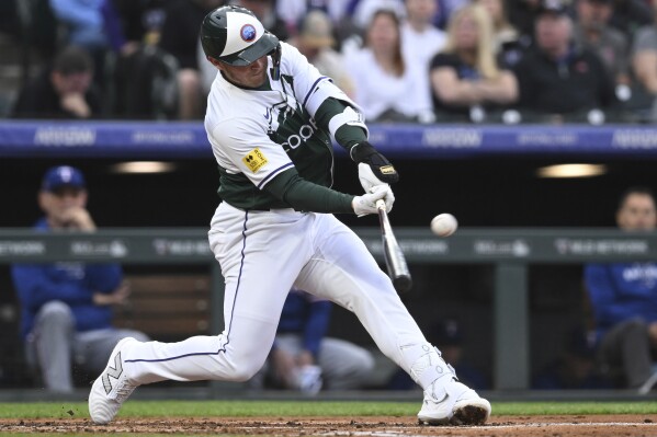 Colorado Rockies' Hunter Goodman hits a home run in the third inning of a baseball game against the Texas Rangers, Saturday, May 11, 2024, in Denver. (AP Photo/Jerilee Bennett)