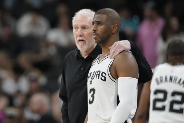 San Antonio Spurs head coach Gregg Popovich, left, talks with guard Chris Paul (3) during the first half of a preseason NBA basketball game against the Orlando Magic in San Antonio, Wednesday, Oct. 9, 2024. (AP Photo/Eric Gay)