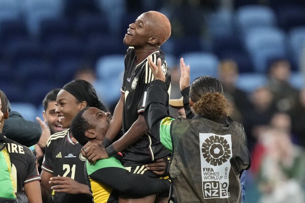 Jamaica's Deneisha Blackwood, center, celebrates with teammates and coaching staff after the Women's World Cup Group F soccer match between France and Jamaica at the Sydney Football Stadium in Sydney, Australia, Sunday, July 23, 2023. The match ended in a 0-0 draw. (AP Photo/Mark Baker)