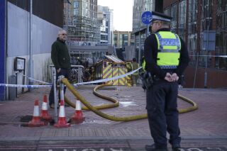 The scene at the Station Hill development site in Reading where a fire broke out trapping a workman on the roof in Reading, England, Thursday Nov. 23, 2023. A crane operator played down tributes paid to him on Thursday after he lifted a man to safety from a burning high-rise building in England. (Lucy North/PA via AP)