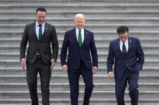 From left, Irish Prime Minister Leo Varadkar, President Joe Biden, and Speaker of the House Mike Johnson, R-La., walk down the steps following the annual St. Patrick's Day gathering at the Capitol in Washington, Friday, March 15, 2024. (AP Photo/J. Scott Applewhite)