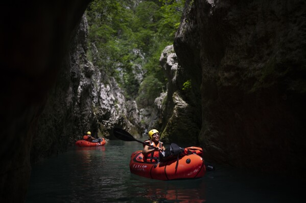 Tourists practice packrafting along the Verdon Gorge in southern France, Monday, June 19, 2023. Human-caused climate change is lengthening droughts in southern France, meaning the reservoirs are increasingly drained to lower levels to maintain the power generation and water supply needed for nearby towns and cities. It's concerning those in the tourism industry, who are working out how to keep their lakeside businesses afloat. (AP Photo/Daniel Cole)