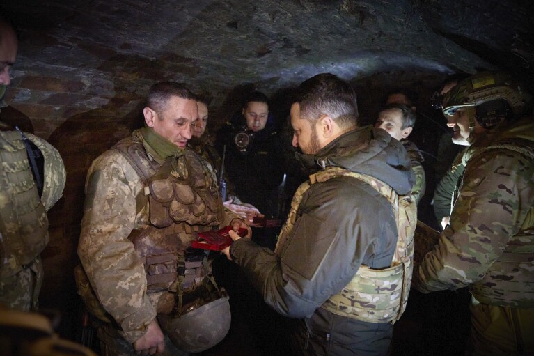 In this photo provided by the Ukrainian Presidential Press Office, Ukrainian President Volodymyr Zelenskyy, centre right, awards serviceman during his visit to Zaporizhzhia region, the site of fierce battles with the Russian troops in Ukraine, Sunday, Feb. 4, 2024. (Ukrainian Presidential Press Office via AP)
