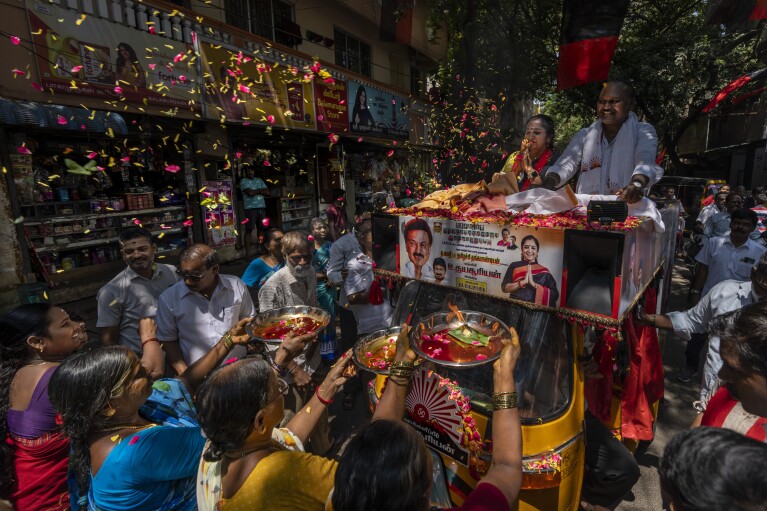 Supporters welcome Dravida Munnetra Kazhagam party candidate Thamizhachi Thangapandian, riding an open-roofed tuk-tuk, during an election roadshow in Chennai, in the southern Indian state of Tamil Nadu, April 15, 2024. (AP Photo/Altaf Qadri)