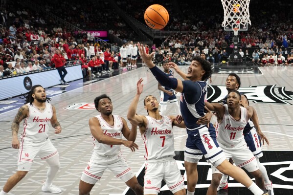 Arizona guard KJ Lewis (5) puts up a shot during the first half of an NCAA college basketball game against Houston for the championship in the Big 12 Conference tournament, Saturday, March 15, 2025, in Kansas City, Mo. (AP Photo/Charlie Riedel)