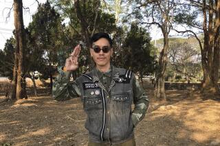 Political activist Mongkhon Thirakot flashes the pro-democracy gesture of a three-finger salute ahead of going to a court in Thailand's northern province of Chiang Rai, Thailand, Thursday Jan. 26, 2023. Mongkhon has been sentenced to 28 years in prison for the crime of insulting the king in posts he uploaded to Facebook. (Thai Lawyers for Human Rights via AP)
