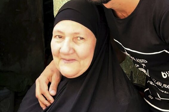 This undated handout image provided by the family of El-Sayed, shows Ghaliya Abdel-Wahab, who died from COVID-19 on April 6, 2020, poses for a photograph with her grandson, in the Shubra el-Kheima neighborhood, Qalyoubiya governorate, Egypt. The novel coronavirus struck her family with horrific speed, infecting 45 of her relatives. (El-Sayed family via AP)