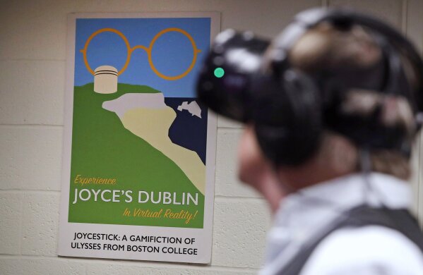 
              In this Jan. 26, 2017, photo, Joseph Nugent, a professor of English at Boston College, wears virtual reality goggles at the school's virtual reality lab in Boston. College students in Boston are developing a virtual reality game based on James Joyce’s ponderous tome “Ulysses.” Nugent says the goal of “Joycestick” is to expose new audiences to the works of one of Ireland’s most celebrated authors and to give a glimpse of how virtual reality can be used to enhance literature. (AP Photo/Charles Krupa)
            
