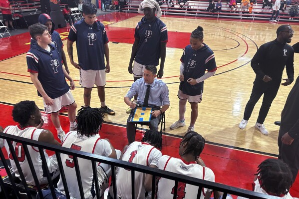 Antelope Valley coach Jordan Mast talks with his team during a timeout during a first-round game against Huntington (Indiana) in the NAIA men's basketball tournament Friday, March 15, 2024, in Glendale, Ariz. Antelope Valley lost 85-71 to end the season with a 26-5 record. Now they'll head back to California with no college to return to, but with their heads held high after the group persevered through a few uncertain months. (AP Photo/David Brandt)