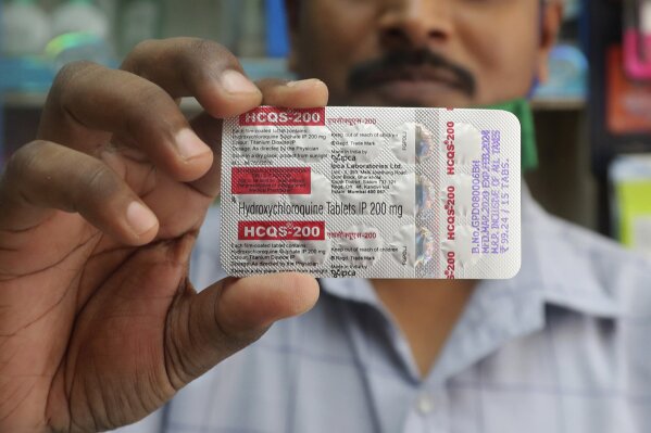 FILE - In this Tuesday, May 19, 2020 file photo, a chemist holds a pack of hydroxychloroquine tablets in Mumbai, India. A Friday, May 22, 2029 report in the journal Lancet shows malaria drugs pushed by U.S. President Donald Trump as treatments for the coronavirus not only did not help but were tied to a greater risk of death and heart rhythm problems in a study of nearly 100,000 patients around the world. (AP Photo/Rafiq Maqbool)