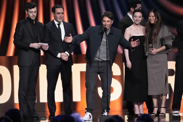 Sean Baker, center, accepts the award for best feature for "Anora" during the Film Independent Spirit Awards on Saturday, Feb. 22, 2025, in Santa Monica, Calif. Appearing with him are from left, Alex Coco, Karren Karagulian, Vache Tovmasyan, Mikey Madison, and Samantha Quan. (AP Photo/Chris Pizzello)