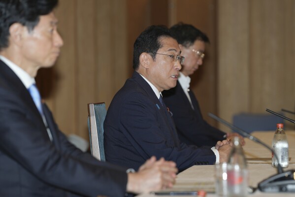 Japanese Prime Minister Fumio Kishida, center, speaks during a meeting with Masanobu Sakamoto, unseen, the head of the National Federation of Fisheries Cooperative Associations and others, unseen, at the prime minister's office in Tokyo Monday, Aug. 21, 2023. Japanese government officials sought understanding from fisheries groups Monday for the impending release of treated radioactive wastewater from the wrecked Fukushima nuclear plant into the sea and pledged to support their livelihoods throughout the process that will take decades. (Zhang Xiaoyu/Pool Photo via AP)