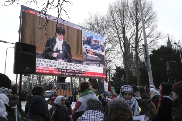 Protestors watch proceedings of a hearing on a giant video screen during a demonstration outside the International Court of Justice in The Hague, Netherlands, Thursday, Jan. 11, 2024. The United Nations' top court opens hearings Thursday into South Africa's allegation that Israel's war with Hamas amounts to genocide against Palestinians, a claim that Israel strongly denies. (AP Photo/Patrick Post)