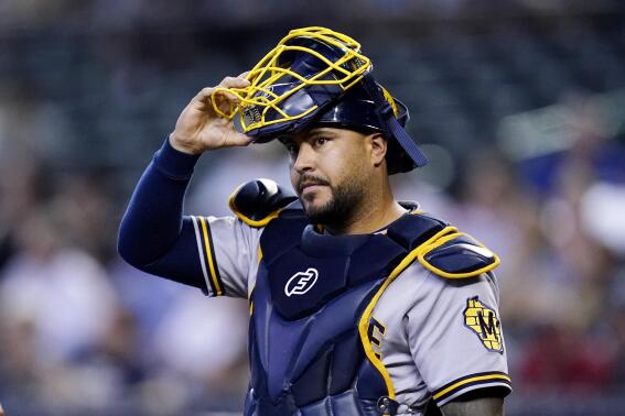 FILE - Milwaukee Brewers catcher Omar Narvaez adjusts his mask during the first inning of a baseball game against the Arizona Diamondbacks, Sept. 4, 2022, in Phoenix. After landing free-agent Narvaez, the New York Mets signed five players to minor league contracts. Narvaez and the Mets agreed to a $15 million, two-year contract, a person familiar with the deal confirmed to The Associated Press. The person spoke on condition of anonymity because the agreement was pending a physical and had not been finalized. (AP Photo/Ross D. Franklin, File)