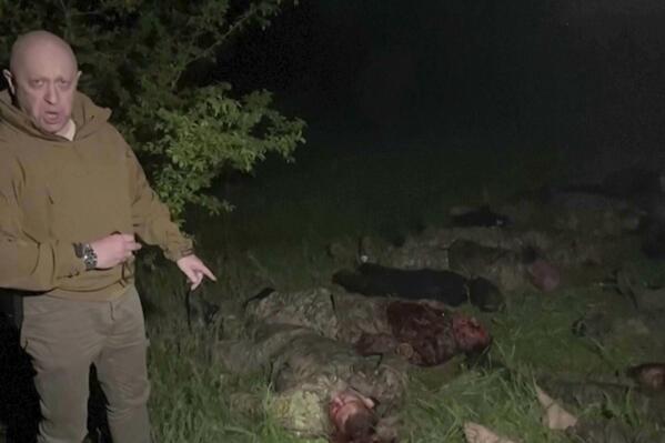 In this handout image taken from a video released by Prigozhin Press Service on Friday, May 5, 2023, head of Wagner Group Yevgeny Prigozhin stands in front of multiple bodies lying on the ground in an unknown location. The owner of Russia's private military company Wagner, Yevgeny Prigozhin, on Friday threatened to pull out Wagner forces from the embattled Ukrainian city of Bakhmut next week, accusing Russia's military command of starving the group of ammunition. (Prigozhin Press Service via AP)