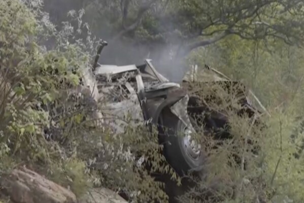 In this image taken from video provided by eNCA, a bus carrying worshippers headed to an Easter festival plunged off a bridge on a mountain pass and burst into flames in Limpopo, South Africa, on Thursday, March 28, 2024, killing multiple people, authorities said. (eNCA via AP)