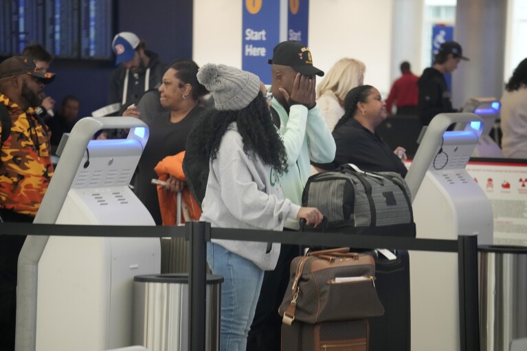 Travellers queue up to check in at the Southwest Airlines counter at Denver International Airport on Monday, Nov. 20, 2023, in Denver. Despite inflation and memories of past holiday travel meltdowns, millions of people are expected to hit airports and highways in record numbers over the Thanksgiving Day break. (AP Photo/David Zalubowski)