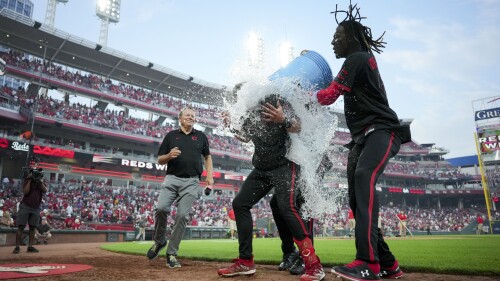 Cincinnati Reds' Spencer Steer, middle, is doused by Will Benson, back, and Elly De La Cruz after hitting a game-winning, two-run home run against the San Diego Padres during the 11th inning of a baseball game in Cincinnati, Friday, June 30, 2023. (AP Photo/Aaron Doster)