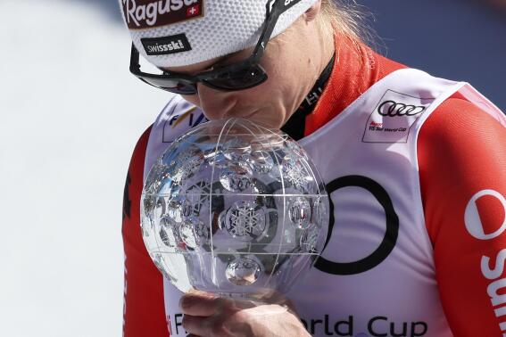 Switzerland's Lara Gut Behrami holds the alpine ski, women's World Cup super-g discipline trophy, in Soldeu, Andorra, Thursday, March 16, 2023. (AP Photo/Alessandro Trovati)
