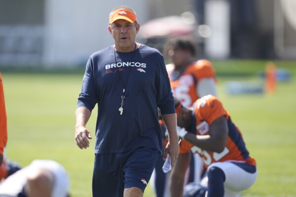 Denver Broncos head coach Sean Payton looks on as players stretch during an NFL football training camp at the team's headquarters Monday, July 31, 2023, in Centennial, Colo. (AP Photo/David Zalubowski)