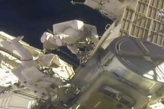 In this image taken from NASA video, NASA astronauts Mike Hopkins, left, and Victor Glover work outside the International Space Station on Monday, Feb. 1, 2021. The pair ventured out on their second spacewalk in under a week Monday to complete a four-year effort to modernize the International Space Station's power grid. (NASA via AP)