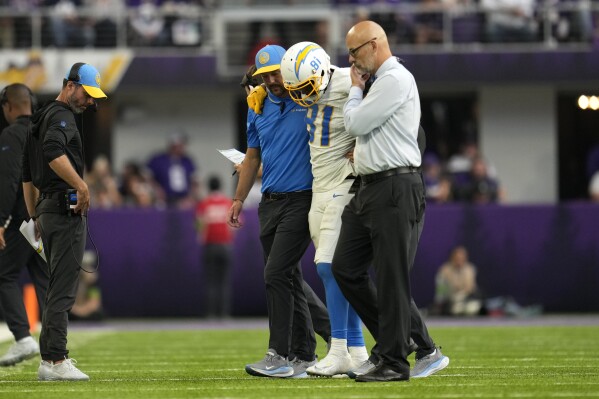 Los Angeles Chargers wide receiver Mike Williams (81) is helped off the field after getting injured during the second half of an NFL football game against the Minnesota Vikings, Sunday, Sept. 24, 2023, in Minneapolis. (AP Photo/Abbie Parr)