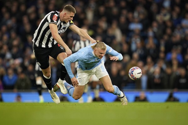 Newcastle's Sven Botman, left, challenges for the ball with Manchester City's Erling Haaland during the FA Cup quarterfinal soccer match between Manchester City and Newcastle at the Etihad Stadium in Manchester, England, Saturday, March 16, 2024. (AP Photo/Dave Thompson)