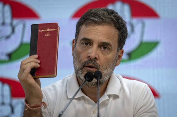 Congress Party leader Rahul Gandhi holds a copy of the Indian Constitution as he addresses a press conference at the party headquarters in New Delhi, India, Tuesday, June 4, 2024. (AP Photo/Altaf Qadri)