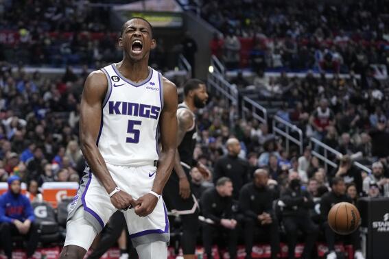 Sacramento Kings guard De'Aaron Fox, left, celebrates after scoring as Los Angeles Clippers forward Marcus Morris Sr. stands in the background during the second half of an NBA basketball game Friday, Feb. 24, 2023, in Los Angeles. (AP Photo/Mark J. Terrill)