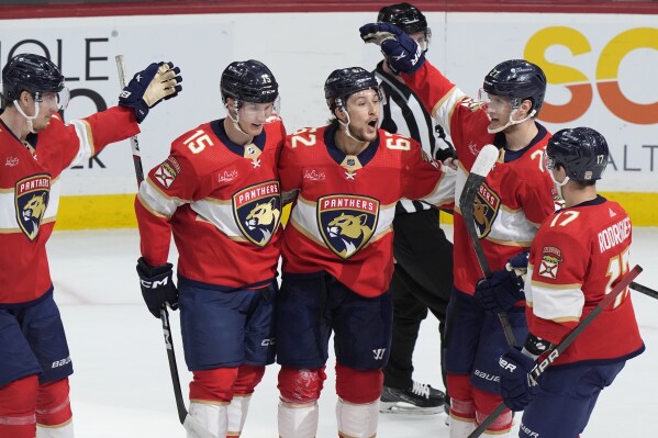Florida Panthers defenseman defenseman Brandon Montour, center, is congratulated by teammates after he score during the second period of an NHL hockey game against the Ottawa Senators, Tuesday, Feb. 20, 2024, in Sunrise, Fla. (AP Photo/Wilfredo Lee)