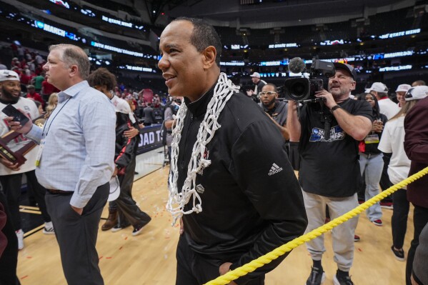 North Carolina State head coach Kevin Keatts wears the net following an Elite Eight college basketball game against Duke in the NCAA Tournament in Dallas, Sunday, March 31, 2024. North Carolina State won 76-64. (AP Photo/Tony Gutierrez)