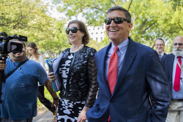 FILE - In this Sept. 10, 2019, file photo, Michael Flynn, President Donald Trump's former national security adviser from Middletown, R.I., leaves federal court with his lawyer Sidney Powell, left, following a status conference in Washington. On Nov. 25, 2020, Trump pardoned Flynn despite Flynn's guilty plea to lying to the FBI about his Russia contacts. (AP Photo/Manuel Balce Ceneta, File)