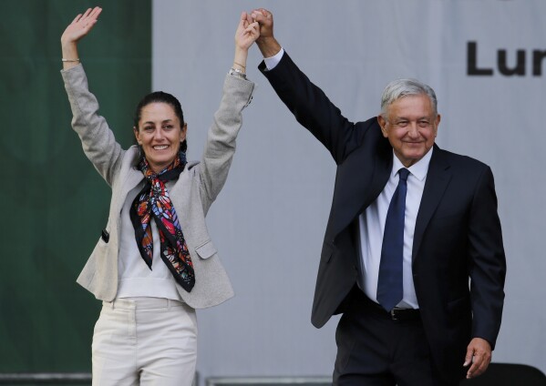 FILE - Mexico's President Andres Manuel Lopez Obrador, right, and then Mayor Claudia Sheinbaum, greet supporters at a rally in Mexico City's main square, the Zocalo, July 1, 2019. Sheinbaum, Mexico’s ruling party presidential candidate, slipped up during a campaign speech Friday, May 10, 2024, and said López Obrador was motivated by “personal ambition,” but later acknowledged the phrase “could be misinterpreted.” In Mexico it is used to describe a desire for personal economic gain. (AP Photo/Fernando Llano, File)