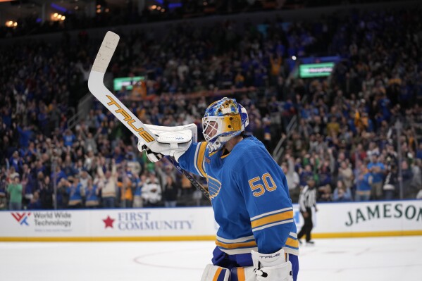 St. Louis Blues goaltender Jordan Binnington celebrates a victory over the Minnesota Wild in a shootout of an NHL hockey game Saturday, March 16, 2024, in St. Louis. (AP Photo/Jeff Roberson)