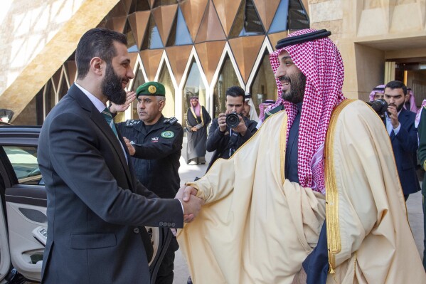 In this photo provided by the Saudi Ministry of Media, Saudi Crown Prince Mohammed bin Salman, right, greets Syria's interim President Ahmad al-Sharaa during his arrival at the royal palace in Riyadh, Saudi Arabia, Feb. 2, 2025. (Saudi Ministry of Media via AP, File)