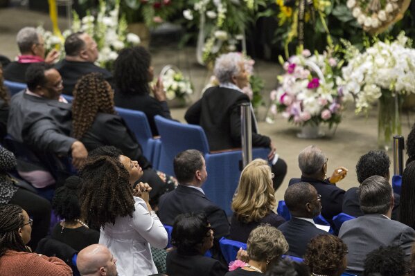 A woman stands during the memorial service for NASA mathematician Katherine Johnson on Saturday, March 7, 2020, at Hampton University Convocation Center in Hampton, Va.   Johnson, a mathematician who calculated rocket trajectories and earth orbits for NASA’s early space missions and was later portrayed in the 2016 hit film “Hidden Figures,” about pioneering black female aerospace workers  died on Monday, Feb. 24, 2020. She was 101. (Kaitlin McKeown /The Virginian-Pilot via AP)