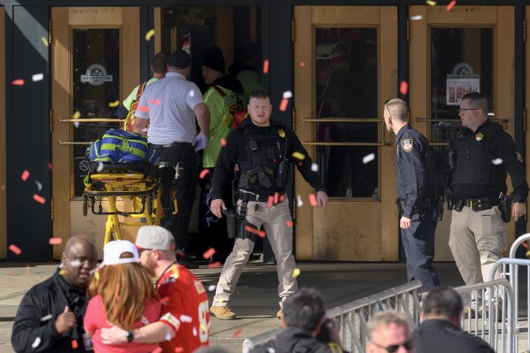 Le personnel d'urgence, à gauche, prend une civière jusqu'à la gare Union à la suite d'une fusillade lors de la célébration du Super Bowl de football de la NFL des Chiefs de Kansas City à Kansas City, Missouri, le mercredi 14 février 2024. Plusieurs personnes ont été blessées, a déclaré un responsable des pompiers. AP Photo/Reed Hoffmann)