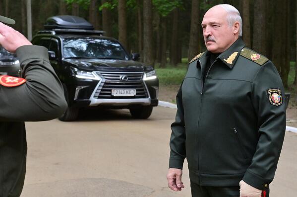 In this handout photo released by Belarus' Presidential Press Office, Belarusian President Alexander Lukashenko listens to an officer's report as he arrives to visit the Central Command Post of the Air Force and Air Defense Forces in Belarus, Monday, May 15, 2023. (Belarus' Presidential Press Office via AP)