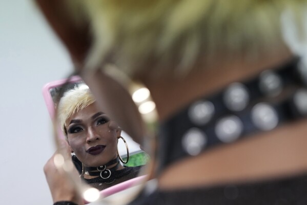 A drag queen applies makeup on her face before a news conference on the Bangkok Pride in Bangkok, Thailand, Thursday, May 9, 2024. Thailand is kicking off its celebration for the LGBTQ+ community's Pride Month with a parade on Saturday, as the country is on the course to become the first nation in Southeast Asia to legalize marriage equality. (AP Photo/Sakchai Lalit)