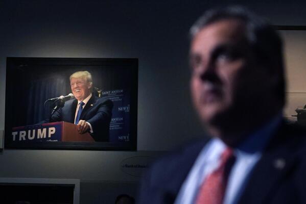 A photograph of former President Donald Trump hangs on the wall as Republican presidential candidate, former New Jersey Gov. Chris Christie listens to a question during a gathering, Tuesday, June 6, 2023, in Manchester, N.H. Christie filed paperwork Tuesday formally launching his bid for the Republican nomination for president after casting himself as the only candidate willing to directly take on Trump. (AP Photo/Charles Krupa)
